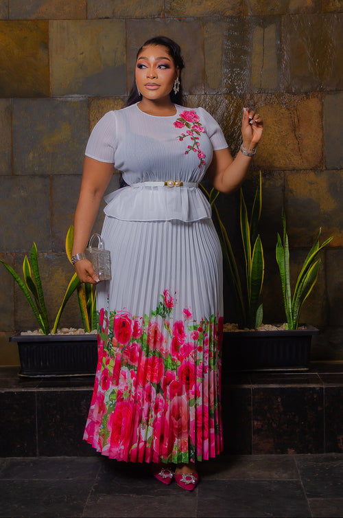 Blossom Beauty white Miyake pleated maxi skirt set featuring a floral peplum top, pearl buckle waist belt and flowing pink rose-print skirt.