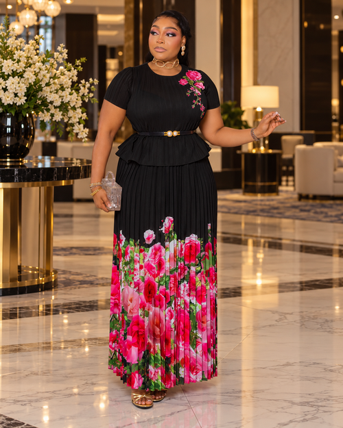 Blossom Beauty black Miyake pleated maxi skirt set featuring a floral peplum top, pearl buckle waist belt and flowing pink rose-print skirt.