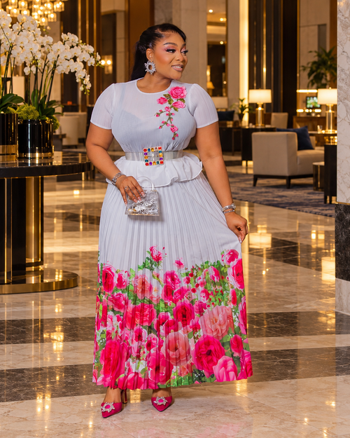 Blossom Beauty white Miyake pleated maxi skirt set featuring a floral peplum top, pearl buckle waist belt and flowing pink rose-print skirt.